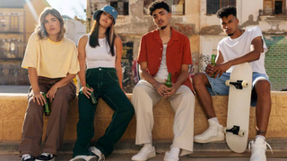 Featured Image - Summer Streetwear Essentials 2026: The Ultimate Style Guide - A Group of men & women together sitting on wall in summer streetwear essentials