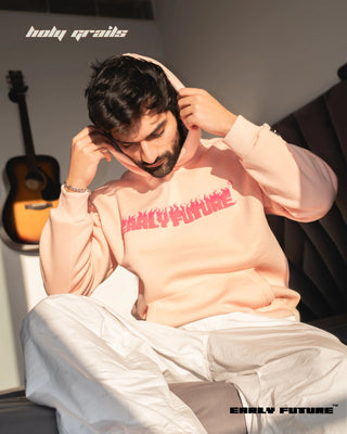 Guy Sitting in Street Style 'Not a Pink Panther' Peach Haze Unisex 360 GSM 100% Cotton Fleece Puff and Screen Graphic Printed Oversize Fit Hoodie - Front