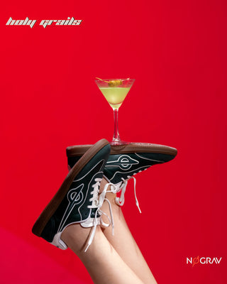 Women wearing Homegrown 'Dirty Martini' Deep Green Premium PU Upper, Cushioned Footbed, Eva Midsole & Rubber Outsole Lightweight Sneaker HG x NoGrav - Sides in Feet and Martini in Glass over Feet