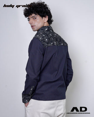 Person wearing a black full sleeve shirt with floral patterns on a plain background