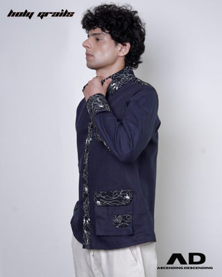 Person wearing a black full sleeve shirt with decorative elements on a plain background