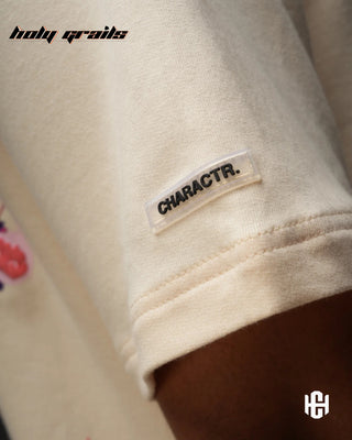 Men in 'The Fortune' Cream 240 GSM Terry Cotton Puff Print Graphic Oversize T-Shirt HG x Charactr - Sleeve Close Up