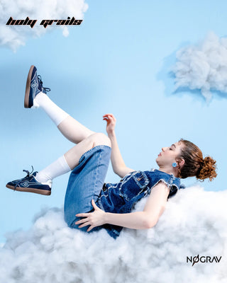 Women in Homegrown 'Azzure' Navy Blue Premium PU Upper, Cushioned Footbed, Eva Midsole & Rubber Outsole Lightweight Sneaker HG x NoGrav - Sides, Laying on her back on Clouds