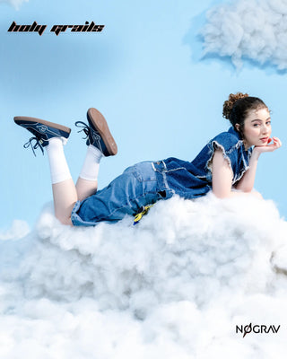Women in Homegrown 'Azzure' Navy Blue Premium PU Upper, Cushioned Footbed, Eva Midsole & Rubber Outsole Lightweight Sneaker HG x NoGrav - Bith Inner & Outer Side, Laying on Her Stomach on Clouds