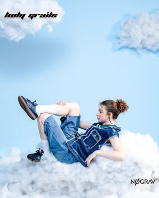 Women in Homegrown 'Azzure' Navy Blue Premium PU Upper, Cushioned Footbed, Eva Midsole & Rubber Outsole Lightweight Sneaker HG x NoGrav - Inner Side, Laying on Her Back in Clouds